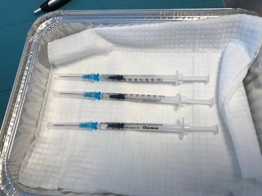 Foliebakke med tre klargjorte vaccinationssprøjter