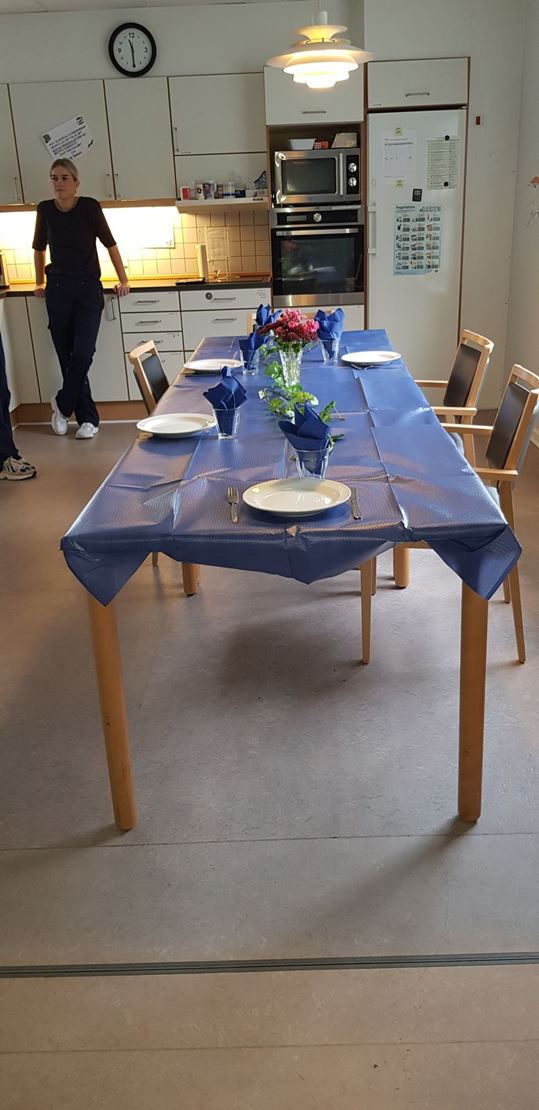 Bord pyntet med blå dug og hvide tallerkner