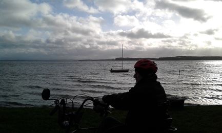 Beboer sidder på sin cykel og kigger ud og Roskildefjorden